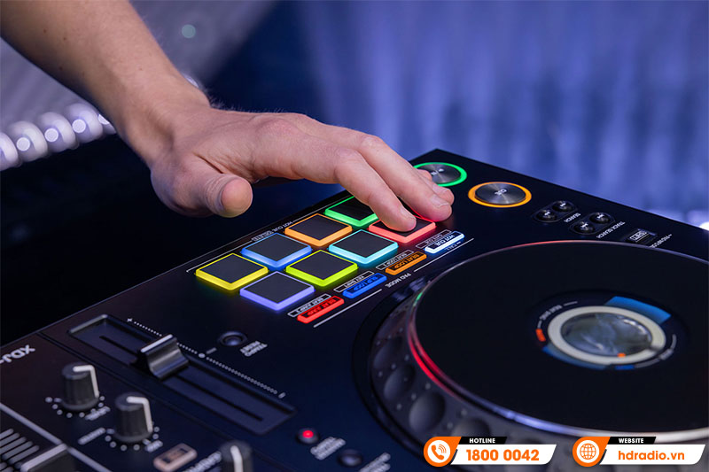 Tay nhấn pad phát sáng trên bàn DJ, hiển thị HOT CUE, ROLL, SLICER, SAMPLER.