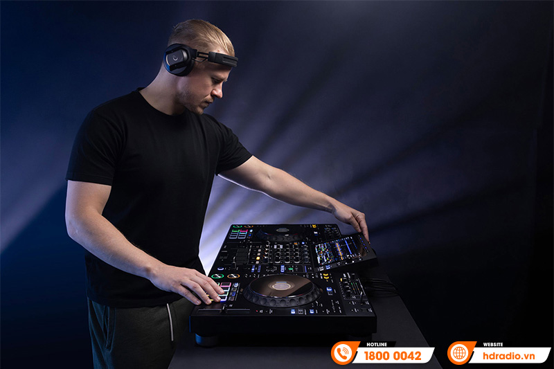 DJ đeo tai nghe kiểm âm điều khiển bộ phối ghép, nền ánh sáng sân khấu