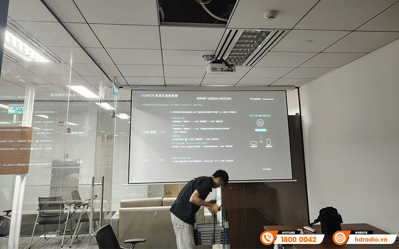 Kỹ thuật viên HDRadio lắp đặt màn chiếu điện Jmgo 120 inch tại văn phòng công ty Đỉnh Việt